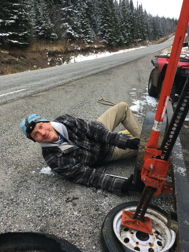 Greg changing tire on the Alcan